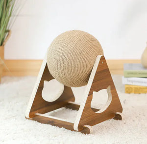 Wooden cat toy with a ball on a stand on a white surface