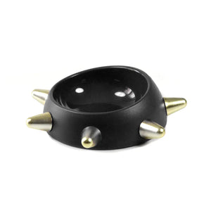 Black bowl with gold spikes on a white background