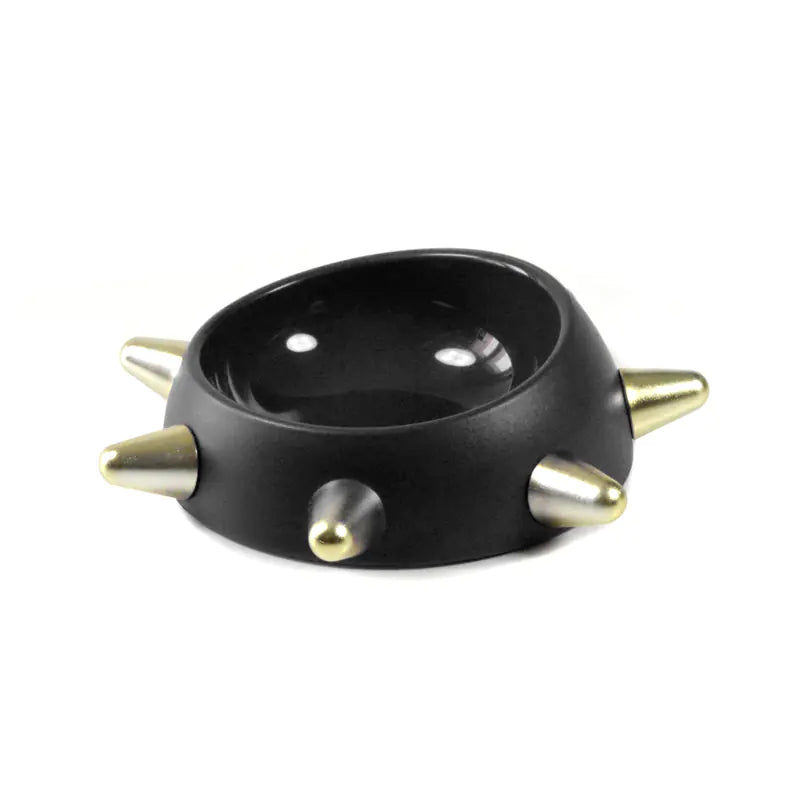Black bowl with gold spikes on a white background