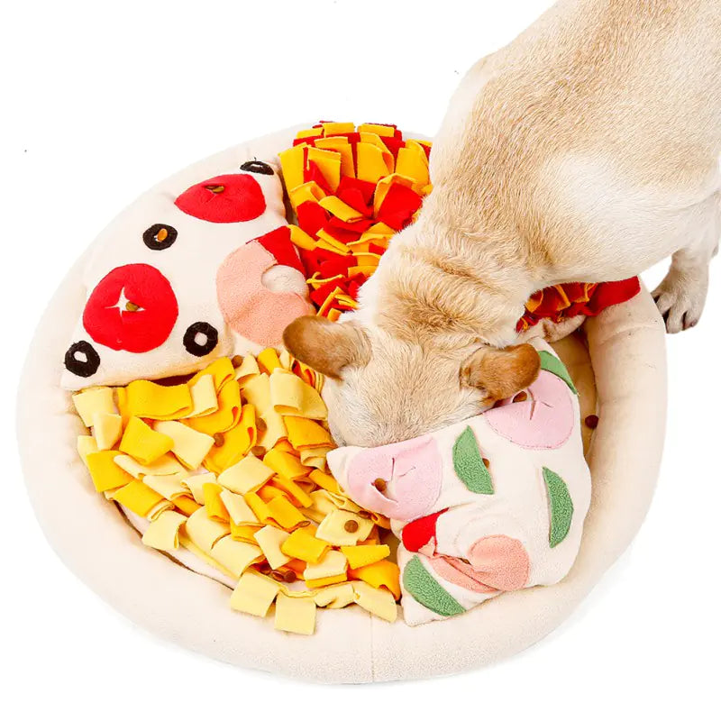 Dog playing with a pizza-shaped chew toy on a white background