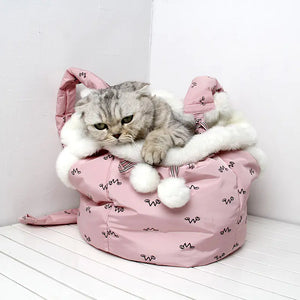 Cat inside a pink pet carrier with white fur on a white floor.