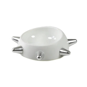 White ceramic bowl with silver spikes on a white background