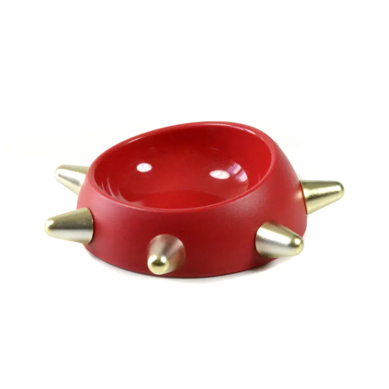 Red ceramic bowl with gold spikes on a white background