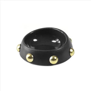 Black bowl with gold studs on a white background