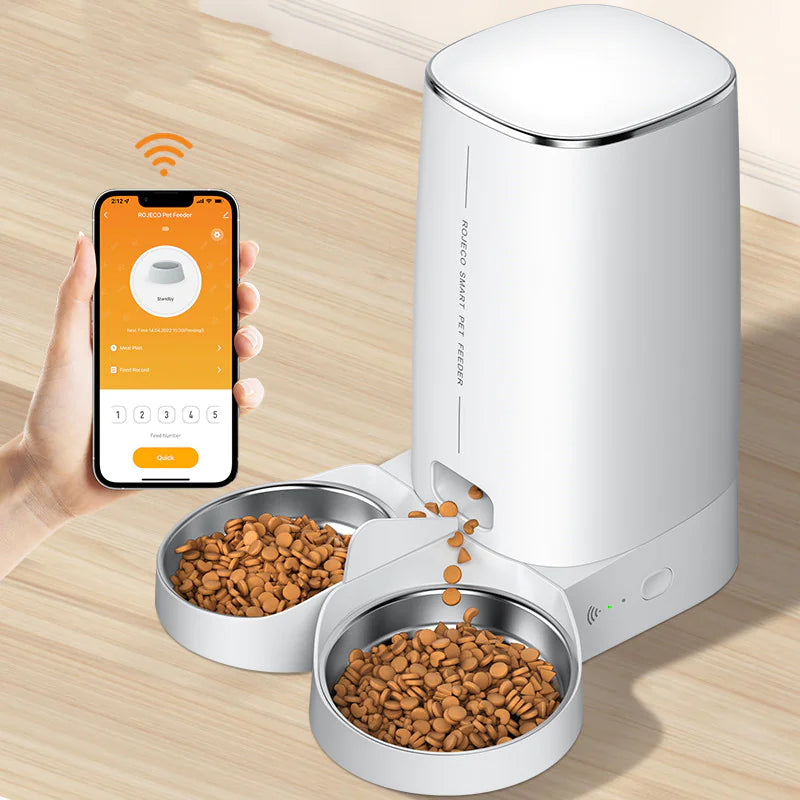 Smart pet feeder dispensing food with a smartphone app interface on a wooden surface