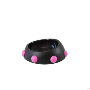 Black bowl with pink polka dots on a white background