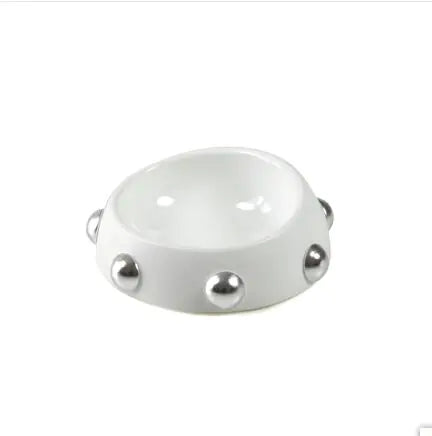 White ceramic bowl with silver studs on a white background